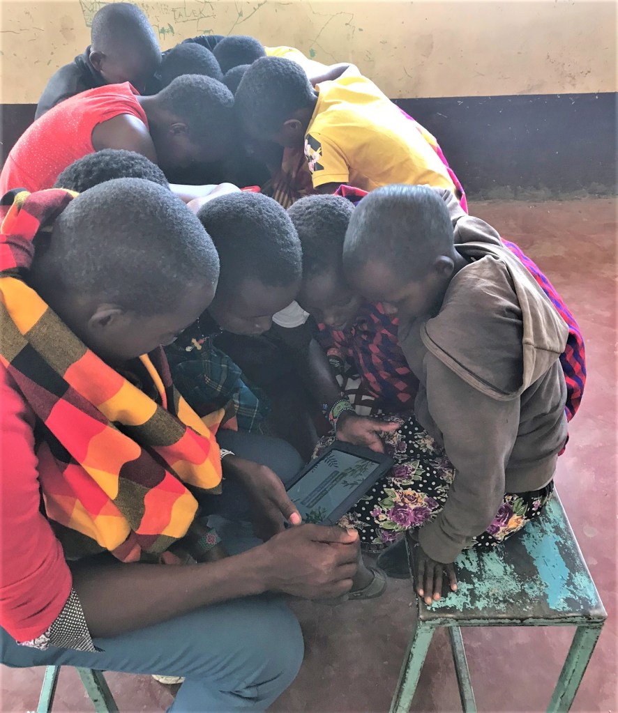 Children in Maasai Mara, Kenya read from an EmpowerReader tablet