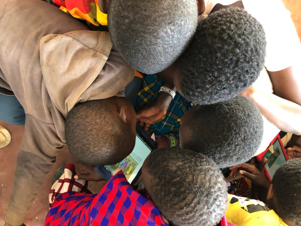 Children in Maasai Mara, Kenya read from an EmpowerReader tablet